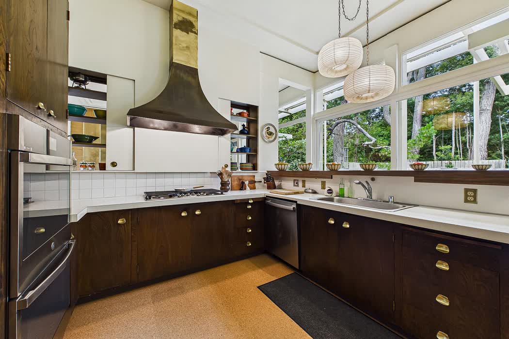 Kitchen with dark timber cabinetry and a run of windows over the sink.