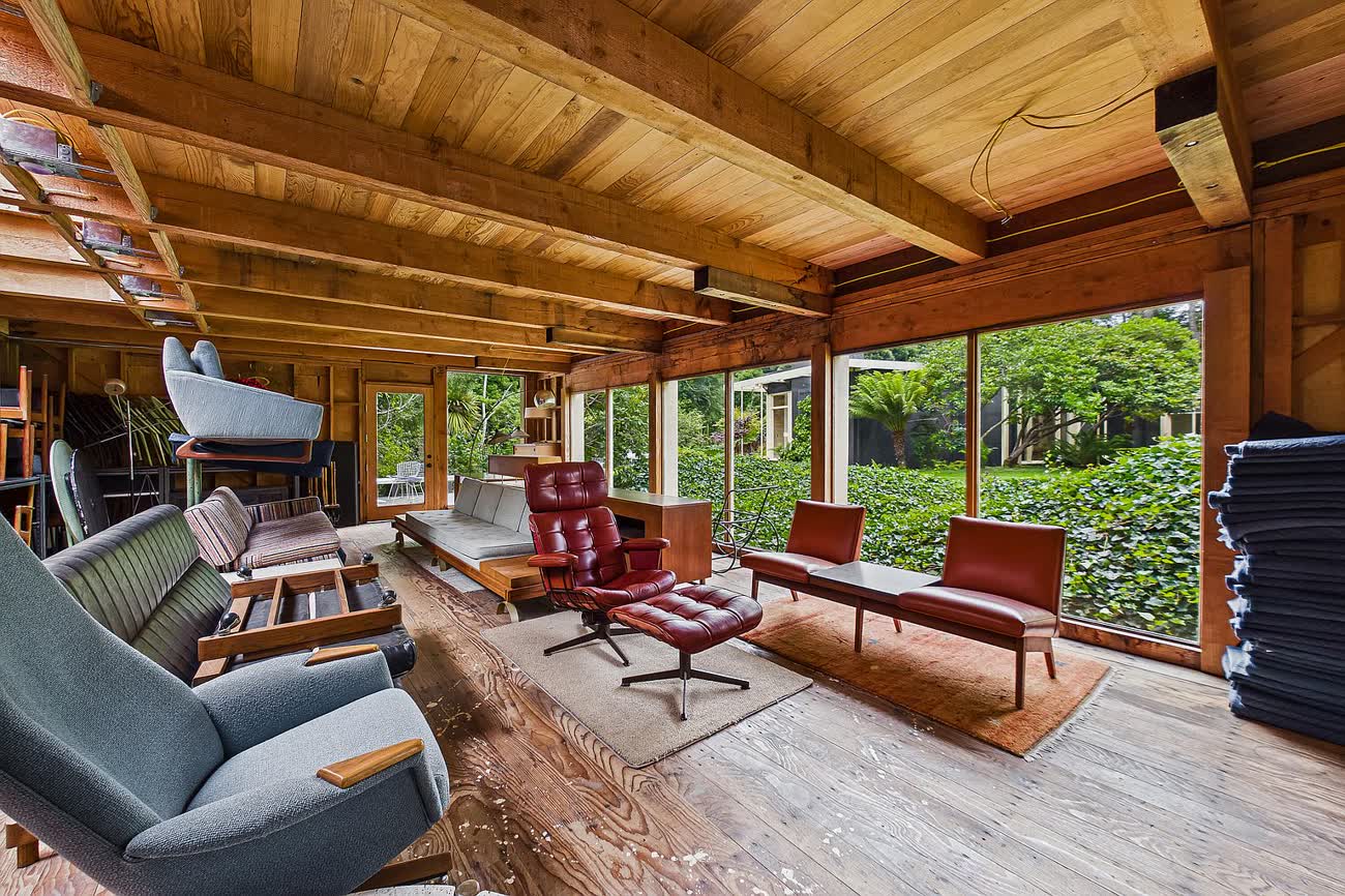 The detached building: an open room under exposed timber rafters with windows to the garden.